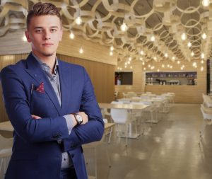 a local business leader stands in front of the dining room of his elegant restaurant