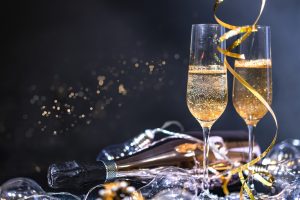 a couple champagne glasses, an empty bottle, and party streamers