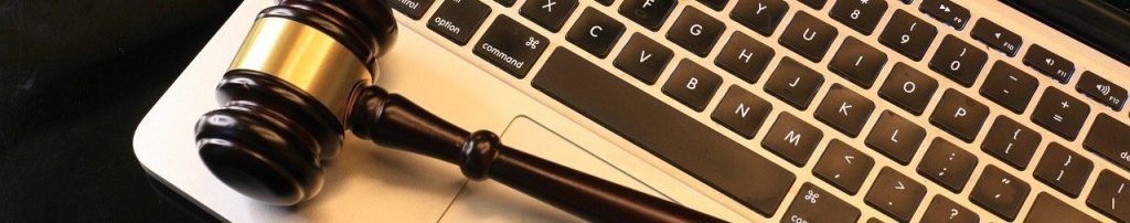 a gavel resting on a laptop keyboard